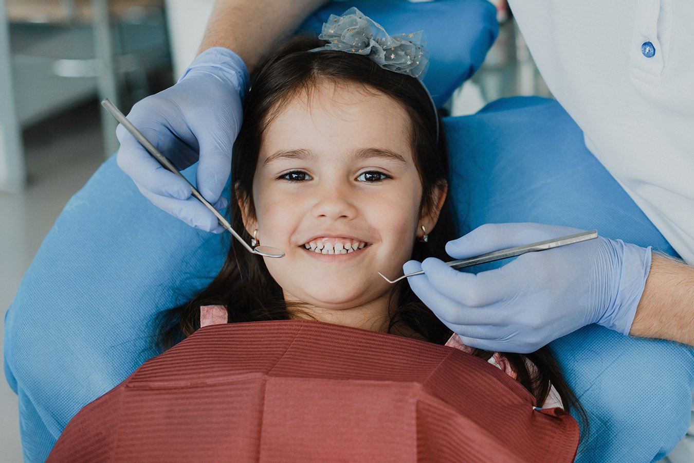 An enthusiastic blonde child with a bright smile sits comfortably in an orthodontic chair, eagerly awaiting Phase 1 treatment. The anticipation of a positive transformation shines through their joyful expression, radiating excitement for the orthodontic journey ahead.